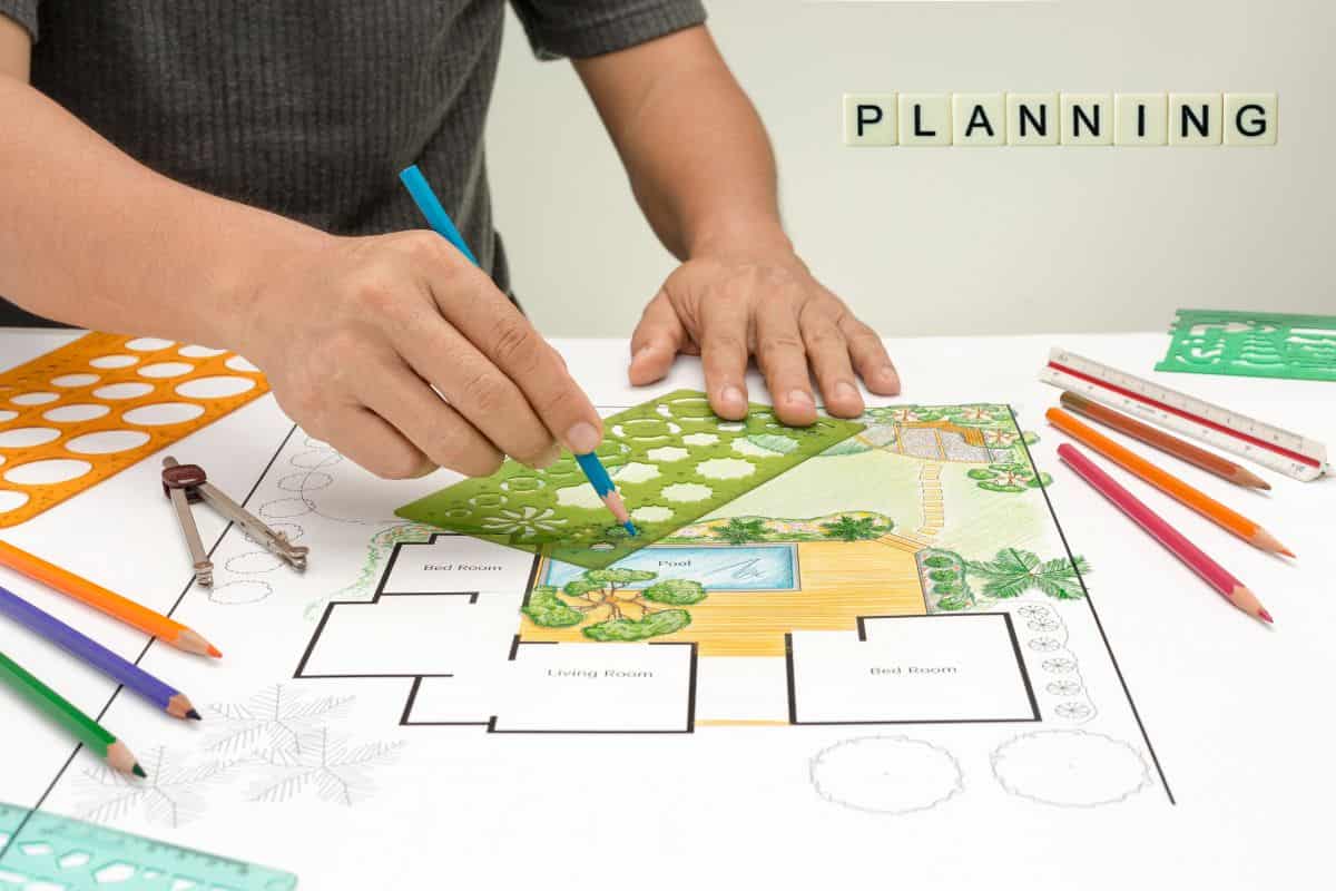 Landscape architect sketching a site plan with a pool and garden